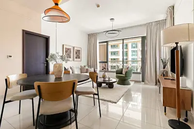 a dining room and living room with a table and chairs at Silkhaus Elite 1BDR at 29 Boulevard Downtown in Dubai