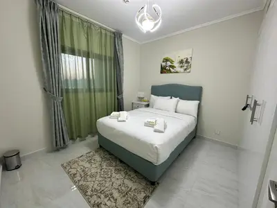 a bedroom with a large bed and a window at Zapbed House-Cozy 2 BR Apartment In The Greens Golf View in Dubai