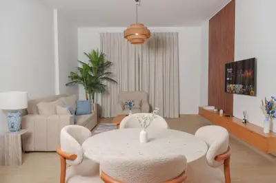 a living room with a table and chairs at High-End Luxury 1BR in Port De La Mer near J1 Beachfront, Dubai in Dubai