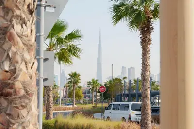 a white van parked on a street with palm trees at High-End Luxury 1BR in Port De La Mer near J1 Beachfront, Dubai in Dubai