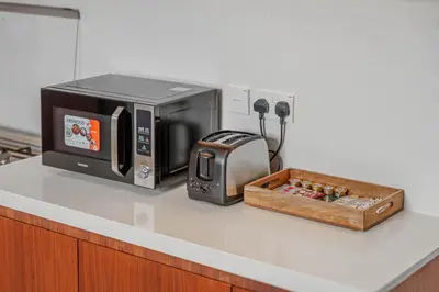 a microwave sitting on a counter next to a box at High-End Luxury 1BR in Port De La Mer near J1 Beachfront, Dubai in Dubai