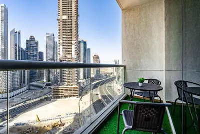 a balcony with a table and chairs and a view of a city at Stylish Studio apartment in Downtown Dubai in Dubai