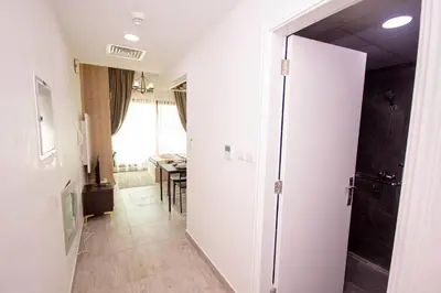 a hallway with a door open to a dining room at Cozy Studio for Daily Rental Warsan in Dubai