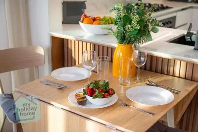 a wooden table with plates of food and wine glasses at Fully furnished with stunning panoramic view in Dubai