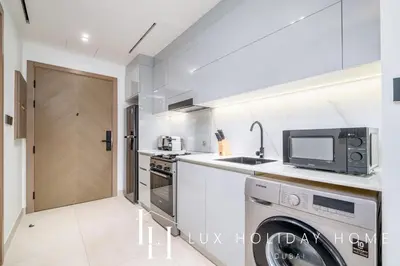 a kitchen with a washer and dryer and a microwave at LUX The Modern Binghatti Canal Suite 2 in Dubai