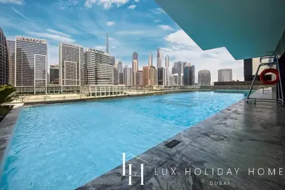 a large swimming pool with a city skyline in the background at LUX The Modern Binghatti Canal Suite 2 in Dubai