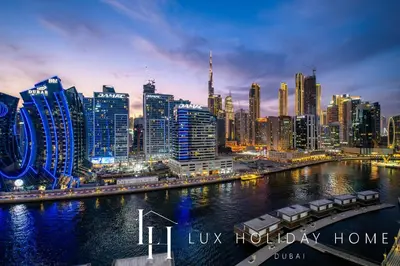 a city skyline at night with a river and buildings at LUX The Modern Binghatti Canal Suite 2 in Dubai