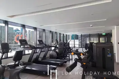 a gym with treadmills and ellipticals in a building at LUX The Modern Binghatti Canal Suite 2 in Dubai
