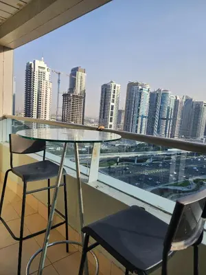 a glass table and chairs on a balcony with a city skyline at Marina Nest - Spacious one bed apt with a view in Marina, walking distance from JBR, metro & tram! in Dubai