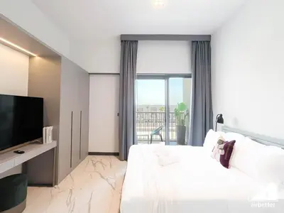 a hotel room with a bed and a flat screen tv at Mag City 920 Modern Studio Minutes from Downtown in Dubai