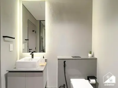 a white bathroom with a sink and a mirror at Mag City 920 Modern Studio Minutes from Downtown in Dubai