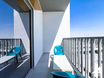 a balcony with a bench and blue chairs at Mag City 920 Modern Studio Minutes from Downtown in Dubai