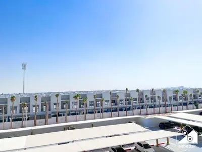 an airport with a parking lot and palm trees at Mag City 920 Modern Studio Minutes from Downtown in Dubai