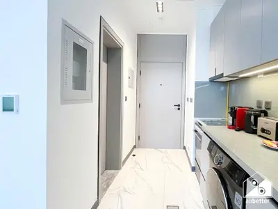 a kitchen with white walls and a white floor at Mag City 920 Modern Studio Minutes from Downtown in Dubai