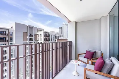 a balcony with a couch and chairs on a balcony at Chic Bright Home in Creek Beach with Lagoon Access in Dubai