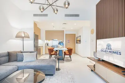 a living room with a couch and a tv and a table at Chic Bright Home in Creek Beach with Lagoon Access in Dubai