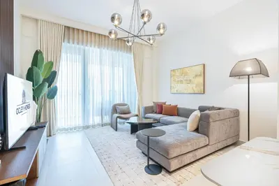 a living room with a couch and a tv at Chic Bright Home in Creek Beach with Lagoon Access in Dubai