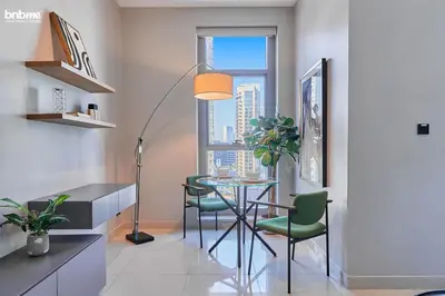 a kitchen with a table and chairs and a window at bnbmehomes - Claren Tower in Dubai