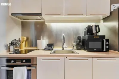 a kitchen with a sink and a microwave at bnbmehomes - Claren Tower in Dubai