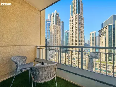 a balcony with two chairs and a view of a city at bnbmehomes - Claren Tower in Dubai