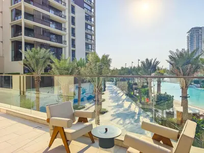 a balcony with chairs and a view of a pool at Beach Escape 1BR-Vida Residences Creek Beach in Dubai