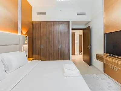 a bedroom with a large bed and a flat screen tv at Beach Escape 1BR-Vida Residences Creek Beach in Dubai