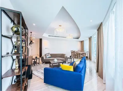 a living room with a blue couch and a table at Female - Girls Joyful Journeys - girls only bedspace in Dubai