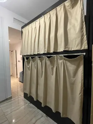 a row of curtains on a wall in a room at Female - Girls Joyful Journeys - girls only bedspace in Dubai