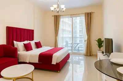 a bedroom with a red bed and a red chair at Comfy Studio in JVC Great Location Fast Wi-Fi in Dubai