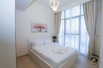 a white bedroom with a bed with two towels on it at Luxury 2-BHK Apartment Located in Azizi riviera 47 Riv 47-419 in Dubai