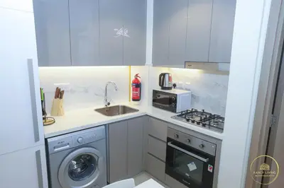 a kitchen with a sink and a stove and a microwave at Luxury 2-BHK Apartment Located in Azizi riviera 47 Riv 47-419 in Dubai