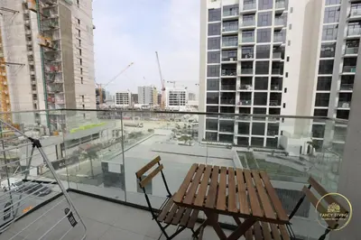 a balcony with a wooden bench and a view of a city at Luxury 2-BHK Apartment Located in Azizi riviera 47 Riv 47-419 in Dubai