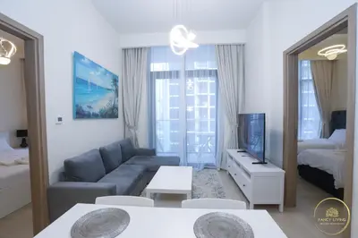 a living room with a couch and a tv and a bed at Luxury 2-BHK Apartment Located in Azizi riviera 47 Riv 47-419 in Dubai