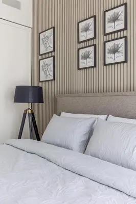 a bedroom with a white bed with four pictures on the wall at Cozy 1 bdr apartment with pool and beach access in Dubai
