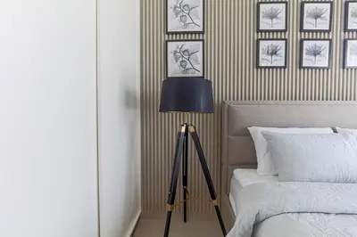a bedroom with a lamp next to a bed at Cozy 1 bdr apartment with pool and beach access in Dubai
