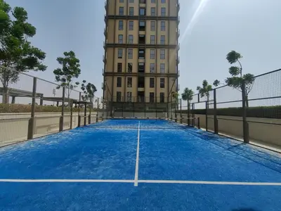a tennis court in front of a building at Cozy 1 bdr apartment with pool and beach access in Dubai
