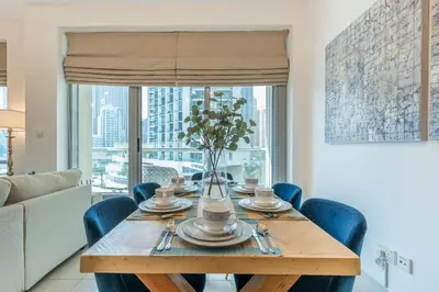 a dining room with a wooden table and blue chairs at Elegant 1BR At Sanibel Tower park Island Tower Dubai Marina by al sarya holiday homes in Dubai