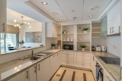a kitchen with white cabinets and a sink at Elegant 1BR At Sanibel Tower park Island Tower Dubai Marina by al sarya holiday homes in Dubai
