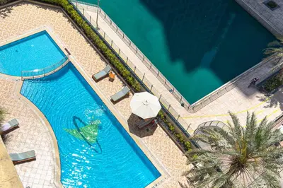 an overhead view of a swimming pool with an umbrella at Chill Studio with Balcony and Pool View in Dubai
