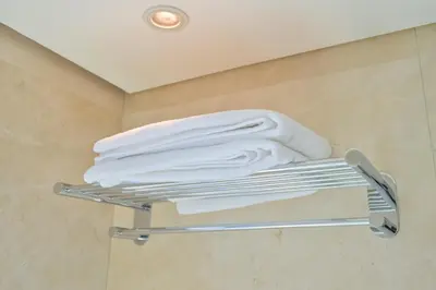 a stack of towels on a towel rack in a bathroom at Studio on the 30th Floor with Stunning Marina View in Dubai