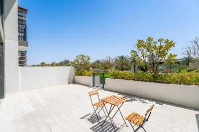 two chairs and a table on a patio at Escape24 Elegant 2BR with Garden View in Dubai Hills in Dubai