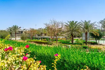a park with pink flowers and palm trees at Escape24 Elegant 2BR with Garden View in Dubai Hills in Dubai
