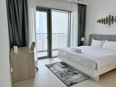 a bedroom with a bed and a large window at DVR 4 BR Apartment available in Downtown View 2 in Dubai