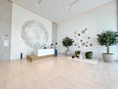 a man standing in a large white room with potted trees at DVR 4 BR Apartment available in Downtown View 2 in Dubai