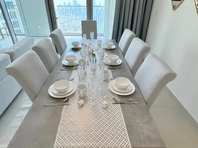 a long table with white plates and glasses on it at DVR 4 BR Apartment available in Downtown View 2 in Dubai