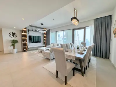 a dining room and living room with a table and chairs at DVR 4 BR Apartment available in Downtown View 2 in Dubai