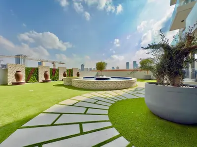 a garden with a fountain in the middle of a lawn at Brand New - Fully Furnished Premium 1BR in JVC in Dubai