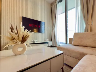 a living room with a couch and a tv at Brand New - Fully Furnished Premium 1BR in JVC in Dubai