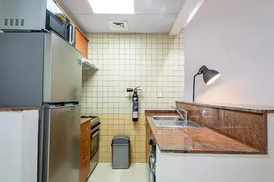 a kitchen with a sink and a refrigerator at Cozy Chic Studio l Next to Marina Mall in Dubai