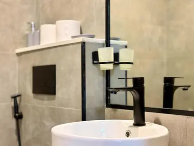 a bathroom sink with a faucet and a mirror at Brand New-Fully Furnished Elegant 1BR In JVC in Dubai